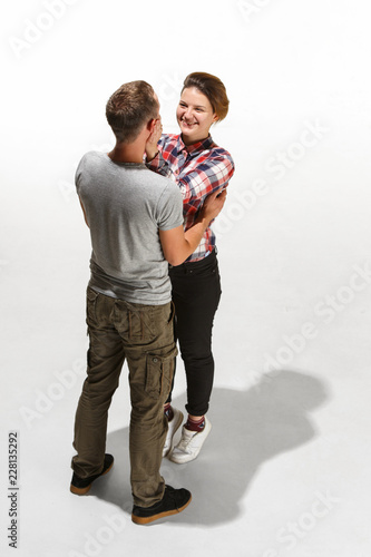 Full body portrait of hugging couple. Caucasian models in love, relationship, dating, flirting, lovers, romantic concept on white studio background. Hugging day concepts