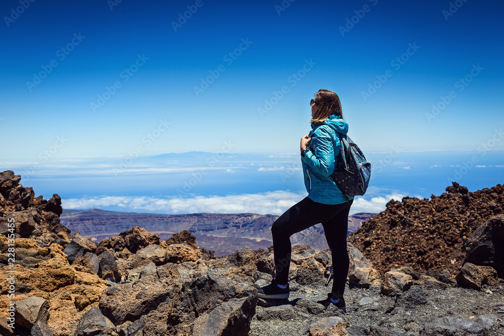 girl over the clouds on top of the mountain by the volcano Teide, Tenerife, Canary Island, Spain