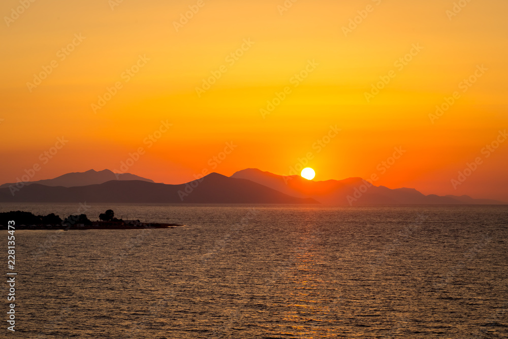 Dramatic sunset over sea surface, Greece Peloponnese. Romantic sunset scenic ocean view in vast Aegean