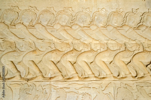 Asuras using the serpent Vasuki to churn the sea on the bas-relief of the Churning of the Sea of Milk in Angkor Wat photo