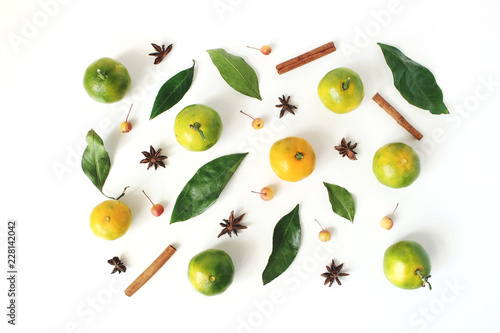 Christmas styled stock composition. Tangerine citrus fruit and leaves, cinnamon sticks, anise stars and little apples on white table background. Christmas, winter holiday concept. Flat lay, top view.