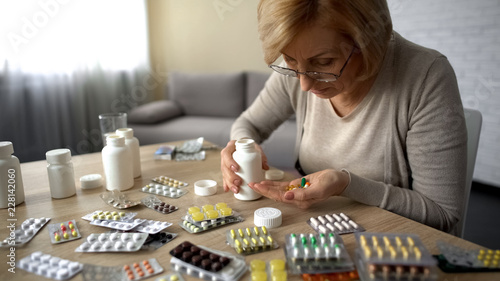 Fotografía Senior lady taking too much pills, feeling unwell, heart problem self-medication
