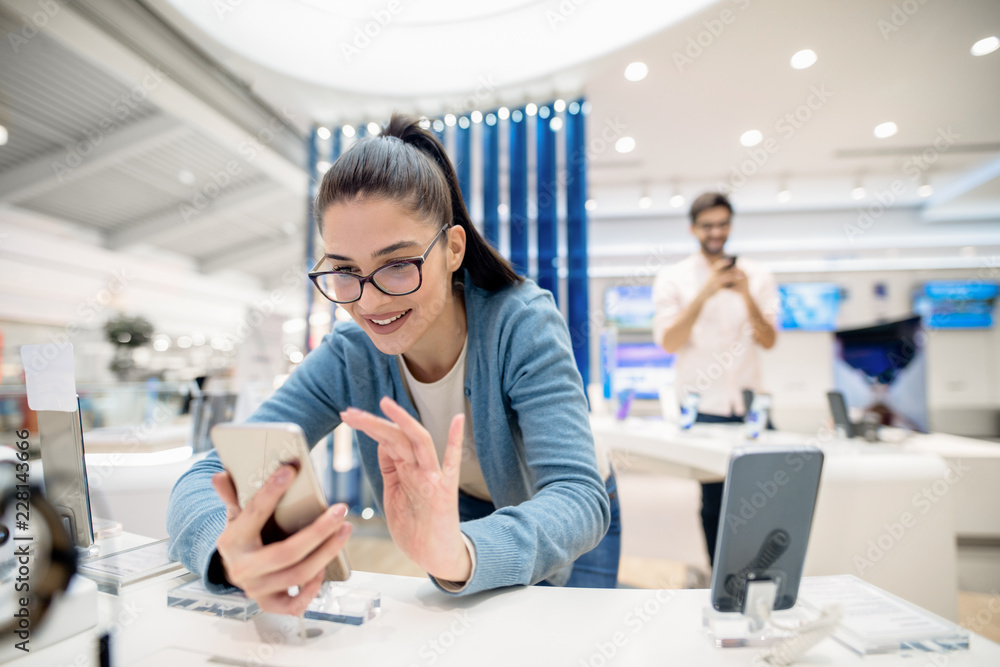 Woman looking for some new smart phone to buy. New technologies concept. Woman looking for some new smart phone to buy. New technologies concept.