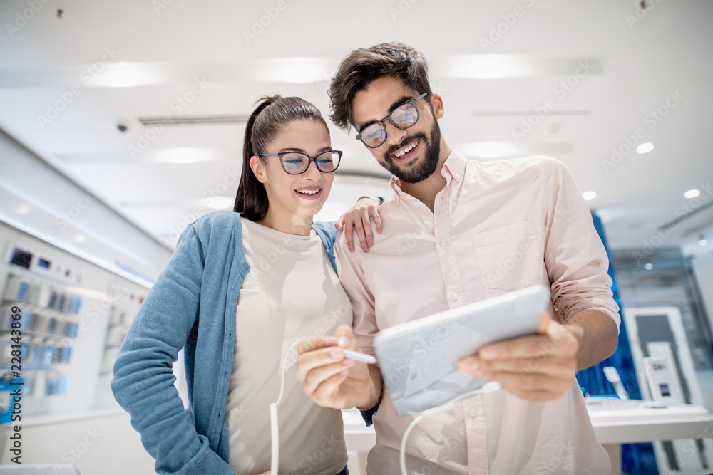 Man showing his girlfriend tablet he want to buy. new technologies concept. Man showing his girlfriend tablet he want to buy. new technologies concept.