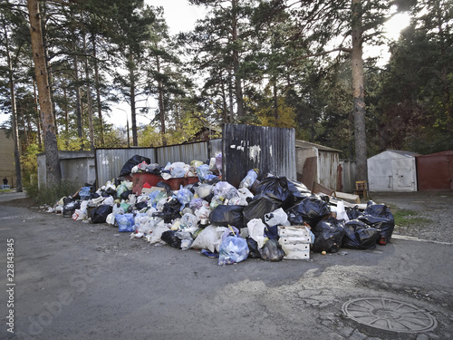 Garbage collection problems - overflowing trash bins. Garbage bags around garbage cans