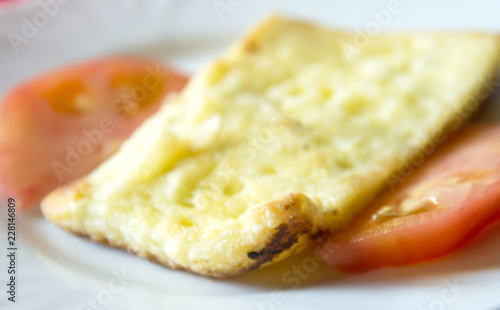 roasted sheep cheese and tomato slices in a plate,shallow dof