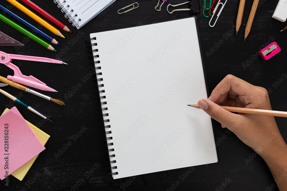 Girl hand drawing, blank paper with colorful pencils and School Supplies on wooden table Girl hand drawing, blank paper with colorful pencils and School Supplies on wooden table