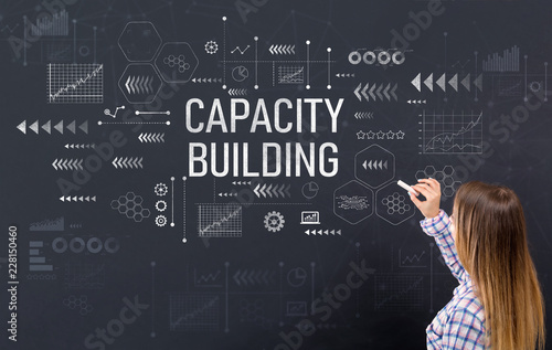 Capacity building with young woman writing on a blackboard