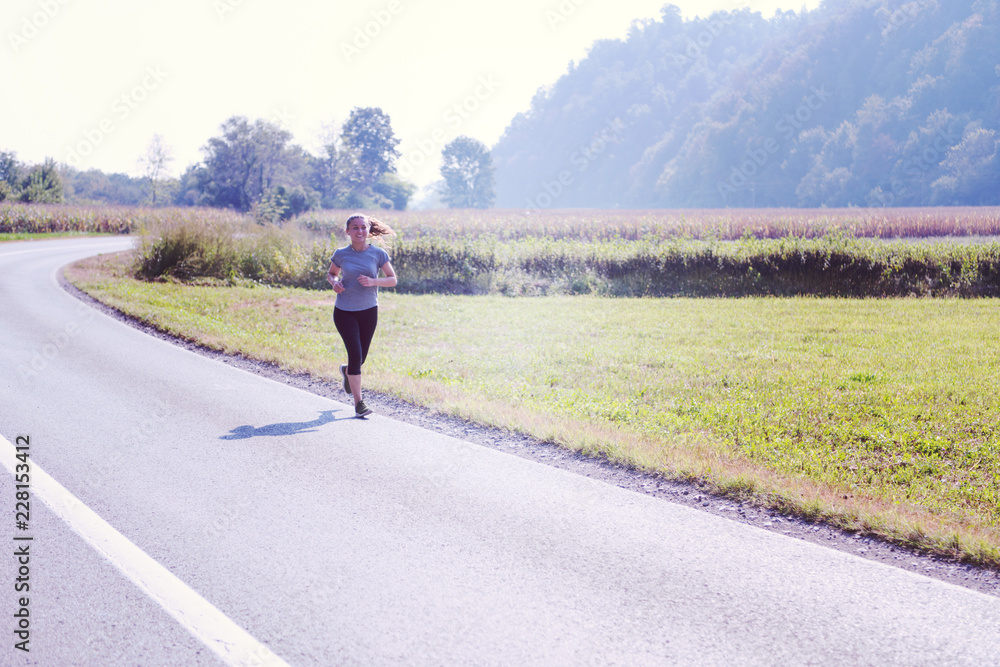 woman jogging along a country road woman jogging along a country road