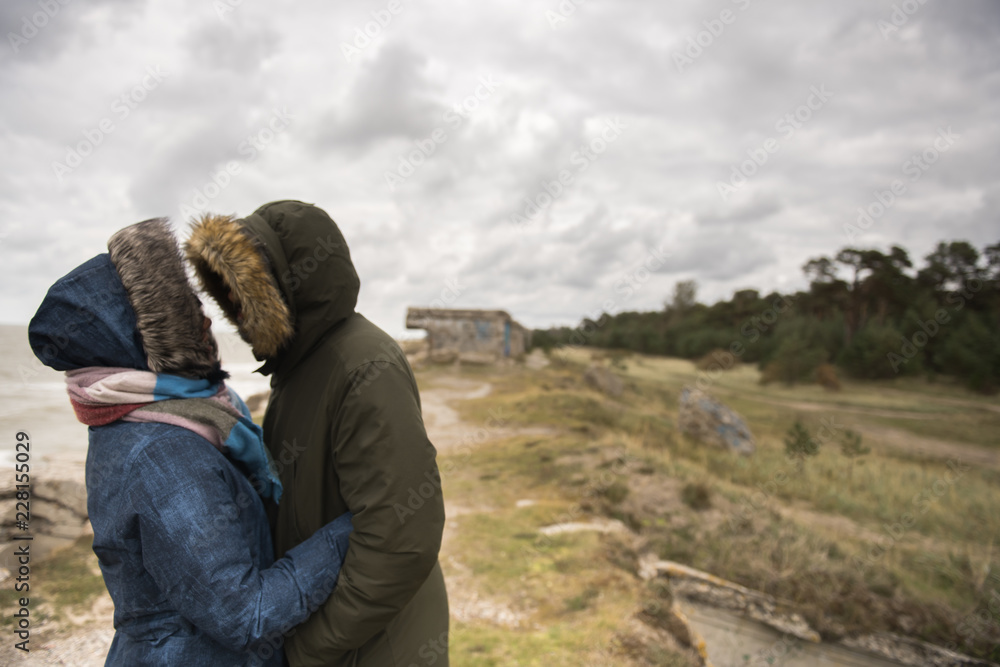 Romantic couple in warm coats on shore Romantic couple in warm coats on shore