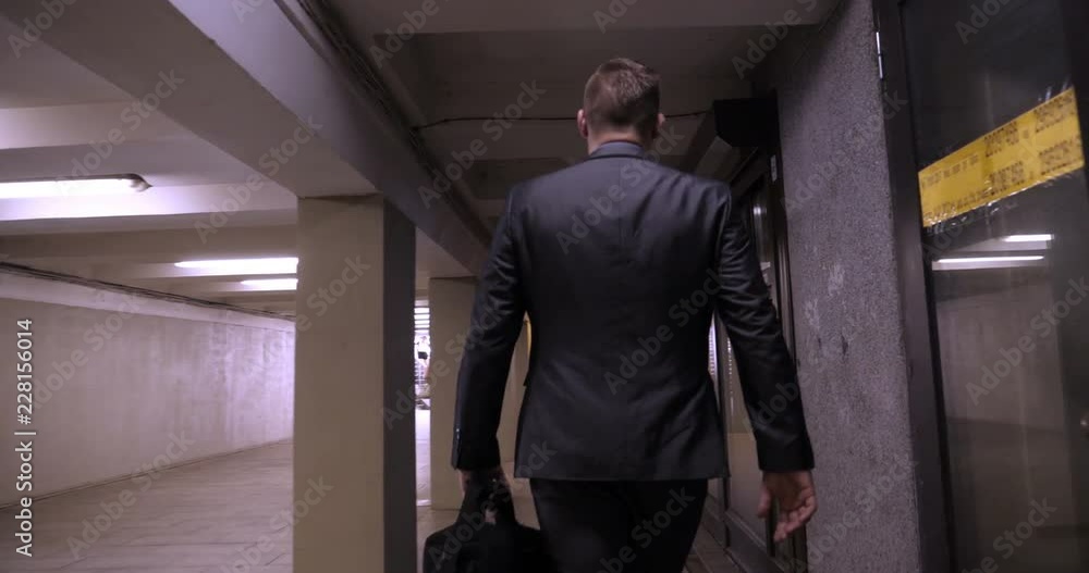 Young handsome guy businessman in a suit, (man) climbs the stairs with a black bag in his hands. Concept: business, suit, guy, man, bag, businessman. Young handsome guy businessman in a suit, (man) climbs the stairs with a black bag in his hands. Concept: business, suit, guy, man, bag, businessman.