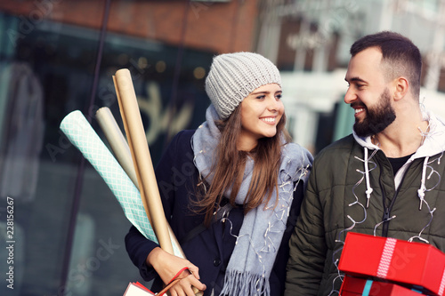 Portrait of happy couple with shopping bags after shopping in city photo