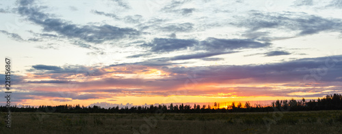 Panorama of sunset over the field in summer