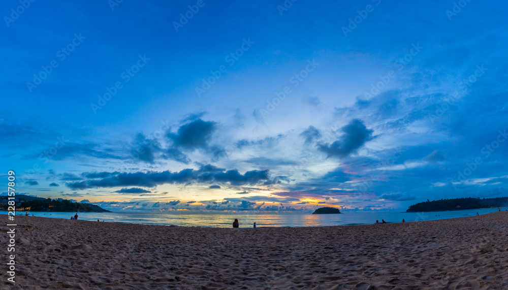 panorama  beautiful sunset behind Pu island at Kata beach Phuket. a lot of tourists relax on the beach during sunset.