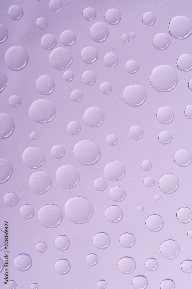 close-up view of transparent water drops on violet background close-up view of transparent water drops on violet background