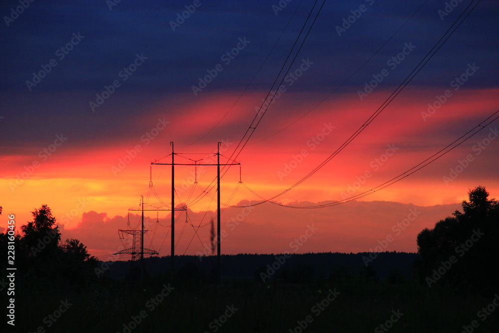 Sunset with crimson clouds and high-voltage line