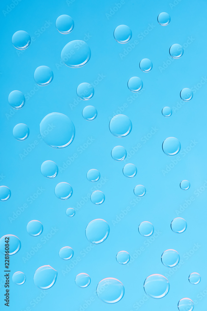 close-up view of transparent water drops on blue background close-up view of transparent water drops on blue background