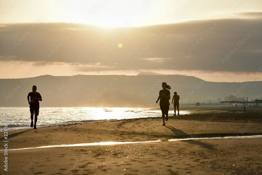 couple running on the beach at sunset