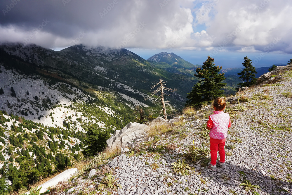 little girl looks at the mountains