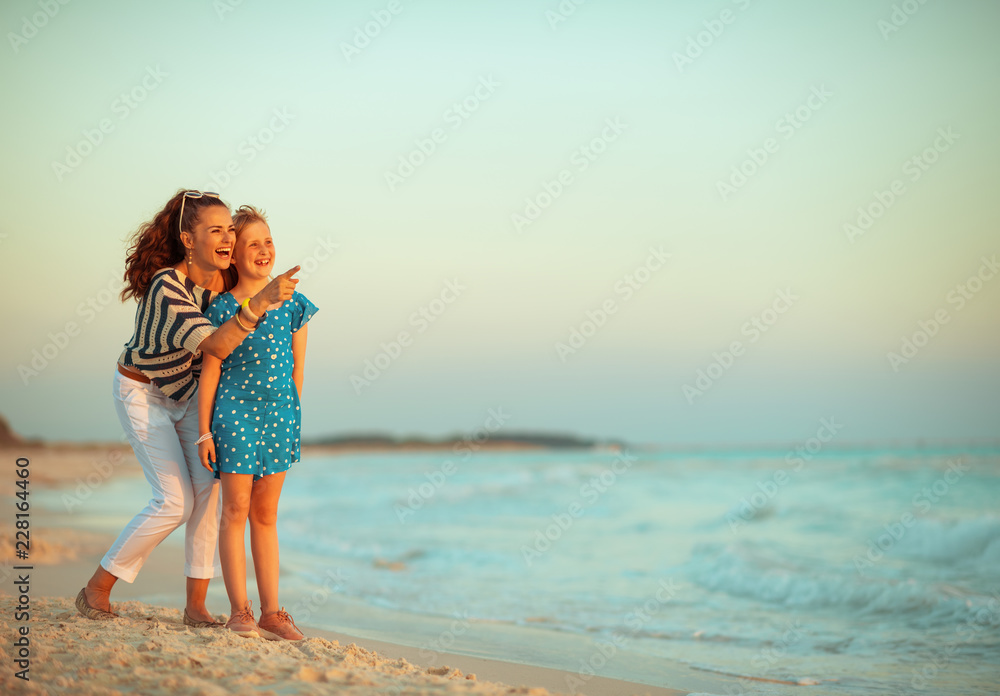 happy young mother and daughter pointing at something happy young mother and daughter pointing at something