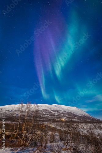 Display of aurora borealis in full moon light  Abisko  Sweden