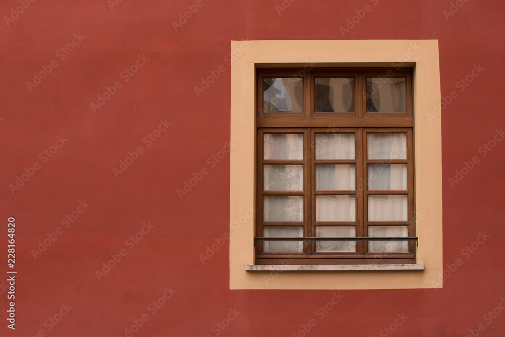 Obraz premium finestra di legno su muro rosso