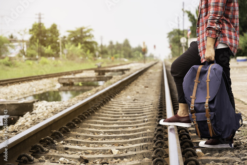 man standing and put his foot on the railway. Backpacker and Travel theme © iHaMoo