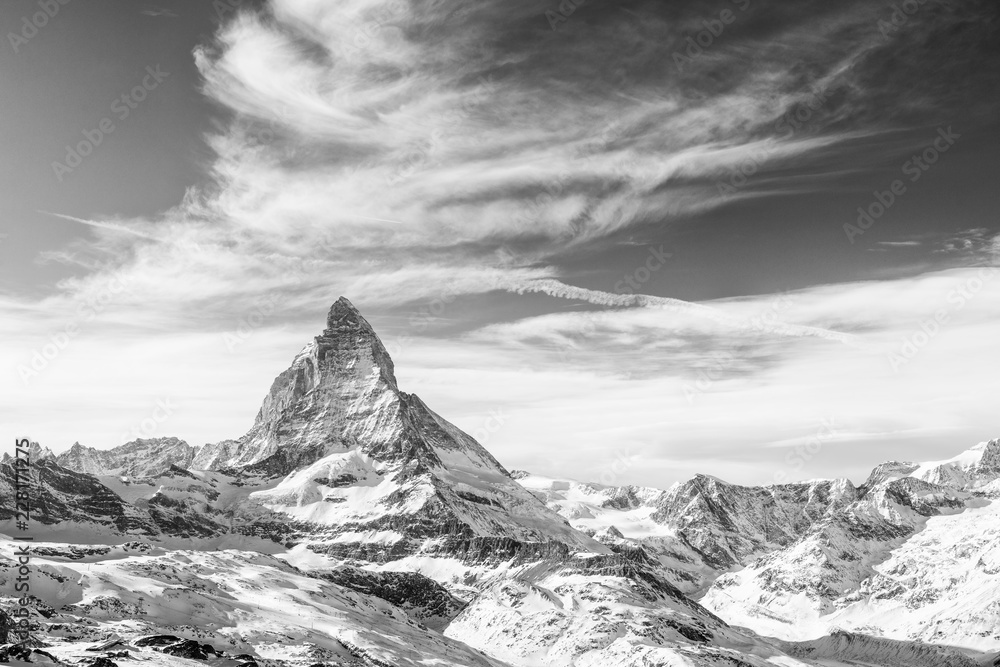 Monochrome view on snowy Matterhorn and other mountains with dramatic sky with clouds, Switzerland