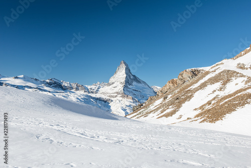 Scenic view on snowy Matterhorn peak in sunny day with blue sky in Switzerland. photo