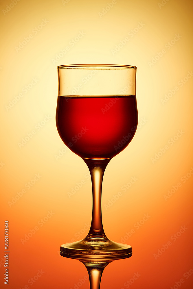 Red wine glass on yellow background