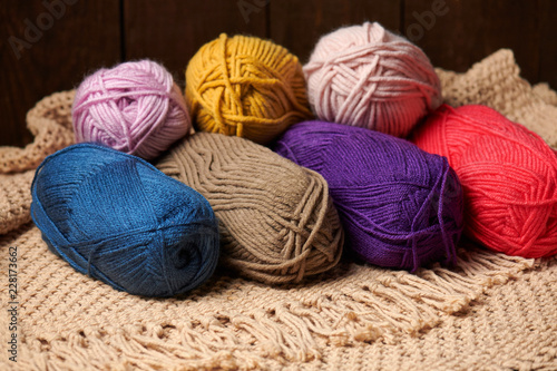 balls of woolen yarn for knitting on wooden background