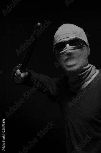 Man in a mask with a police baton.
