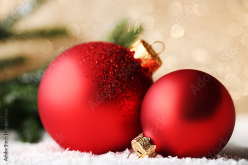 Red christmas baubles with fir-tree branches on lights background