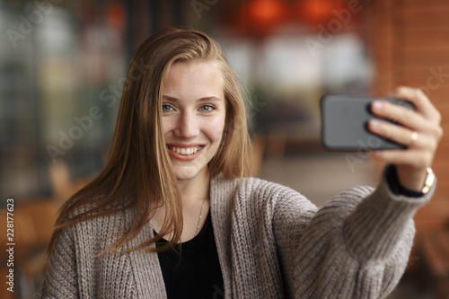 Wallpaper Mural Young woman with shopping bag looking at phone on sunny autumn day. Torontodigital.ca