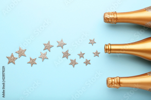 Decorated champagne bottles with stars on blue background