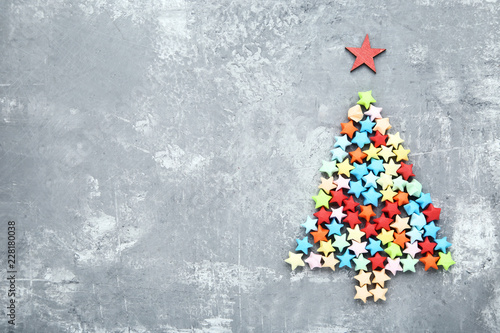 Colorful paper stars in shape of christmas tree on grey wooden table