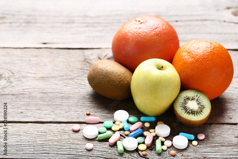 Ripe fruits and colorful pills on wooden table Ripe fruits and colorful pills on wooden table