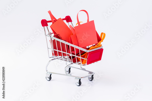 Shopping bag full on shopping cart on white background.