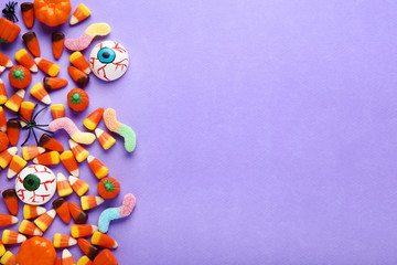 Halloween candy corns and pumpkins on purple background