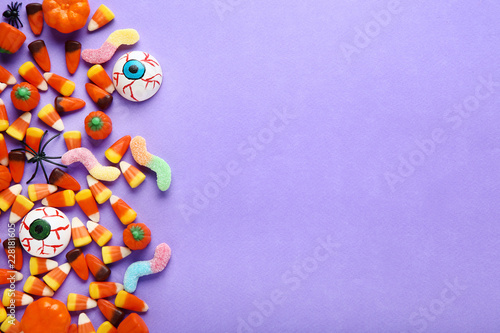 Halloween candy corns and pumpkins on purple background