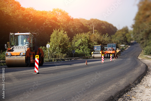 Carrying out repair works: asphalt roller stacking and pressing hot lay of asphalt. Machine repairing road