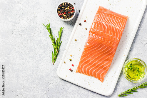 Slice of salmon with pepper, seasalt, herbs and olive oil. Top view, space for text.