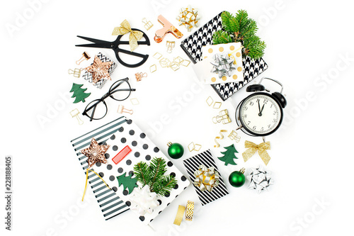 Christmas frame made from winter decorations  stationery with alarm clock and gifts on white background. Holiday and celebration creative concept. Flat lay  top view