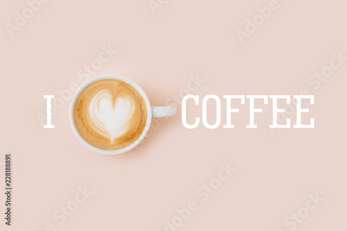 Coffee cup on pale pink background. Flat lay, top view