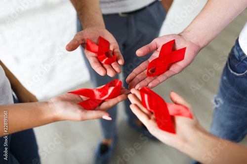 Картината върху платно Group of young multiracial woman with red ribbons in hands are struggling against HIV/AIDS