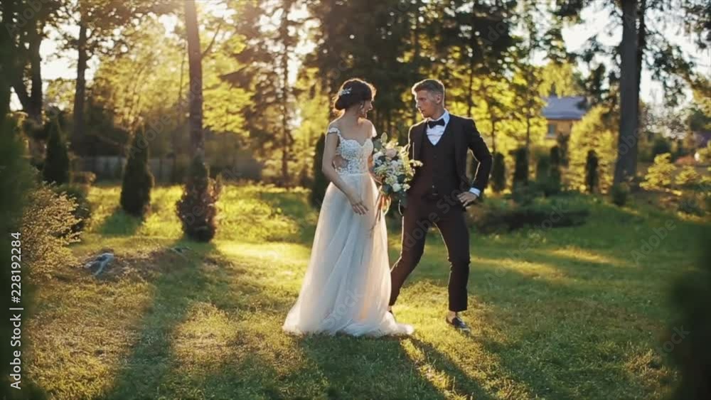 A bride and groom dancing in park in autumn A bride and groom dancing in park in autumn
