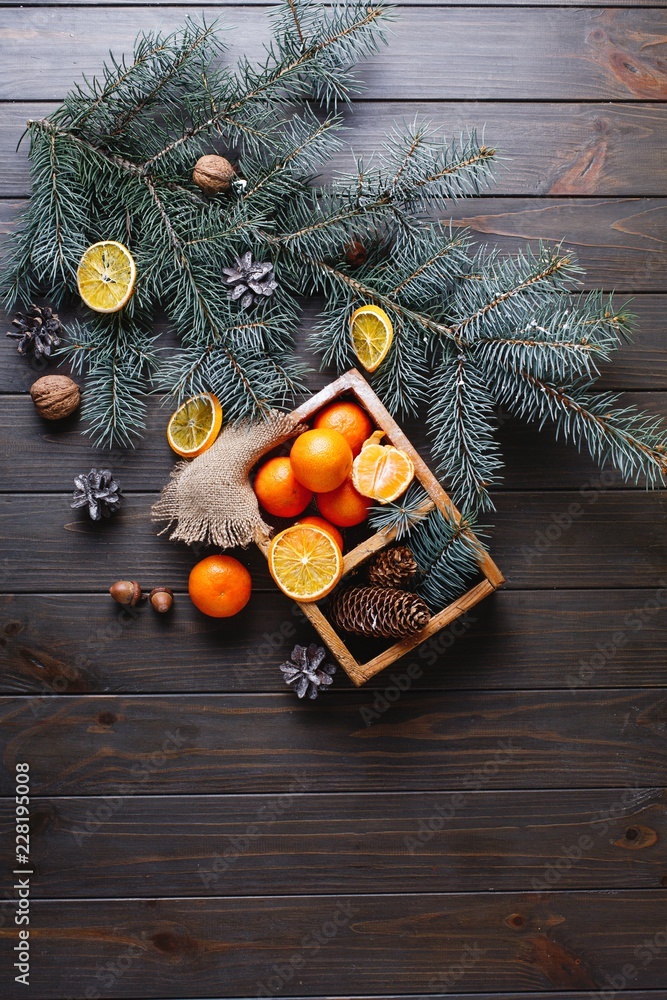 Christmas and New Year decor. Oranges, cones and Christmas tree branches lie on a wooden table Christmas and New Year decor. Oranges, cones and Christmas tree branches lie on a wooden table
