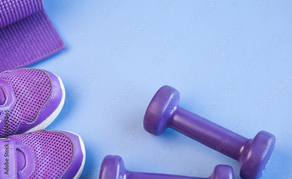 Sports background with copy space. Top view dumbbells, mat, and sneakers. Fitness concept. Sports background with copy space. Top view dumbbells, mat, and sneakers. Fitness concept.