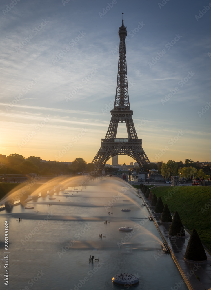 Paris, France - 10 13 2018: View of the Eiffel Tower with water jet from the garden of Trocadero at sunrise