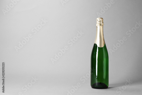Bottle of champagne on grey background. Space for text